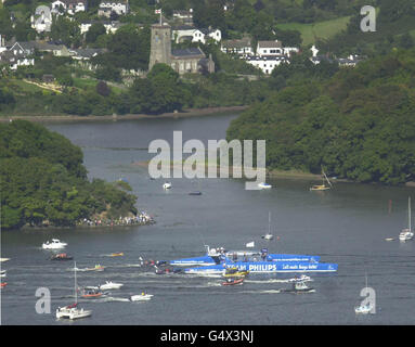 Flottille de petits bateaux suit les 4 millions de catamaran 'Team Philips' comme elle se rend vers Dartmouth après son retour à l'eau à Totnes, Devon. *il y a six mois, une section d'arc de 40 pieds sur le catamaran a éclaté pendant les essais en mer au large des îles de Scilly. Depuis, la plus grande structure de fibre de carbone au monde a été réparée et a subi des travaux pour renforcer ses arcs. L'artisanat a été construit spécifiquement pour la course, un défi non-stop autour du monde qui commence le 31 décembre de Barcelone. Banque D'Images