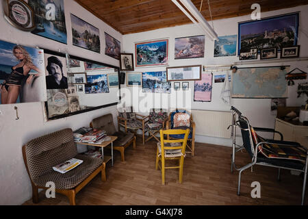 Affiches et photographies couvrent les murs d'un salon de coiffure à Axos, sur l'île de Crète en Grèce Banque D'Images