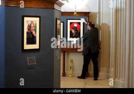 Le conservateur de la Collection royale David Westwood porte une photographie de l'Association de la presse prise en 2001 par la Reine pour assister au Service du jour du souvenir à Whitehall, une partie de la Reine : 60 photographies pour 60 ans d'exposition au château de Windsor. Banque D'Images