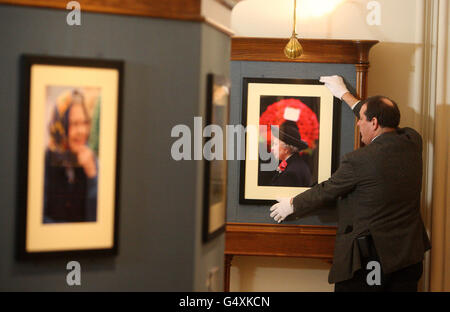 Le conservateur de la Collection royale David Westwood porte une photographie de l'Association de la presse prise en 2001 par la Reine pour assister au Service du jour du souvenir à Whitehall, une partie de la Reine : 60 photographies pour 60 ans d'exposition au château de Windsor. Banque D'Images