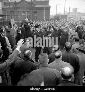 Un spectacle de mains des dockers de Londres indiquant leur désir de retourner au travail, lors de la réunion de masse à l'extérieur du Groupe Royal des docks. La réunion a commencé tardivement car un haut-parleur n'est pas arrivé, et Jack Dash (debout sur un président, à gauche), chef du Comité de liaison des travailleurs du port, a dû crier pour se faire entendre. Les grévistes ont voté pour un retour au travail, mais ils ont donné aux employeurs et aux syndicats jusqu'à la fin de l'année pour négocier leurs demandes. Banque D'Images