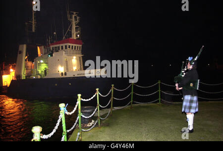 Un joueur solitaire voit dans le bateau Scotian Shore transportant les cadavres des sept victimes de la Solway Harvester sur le quai de Douglas, île de Man. Banque D'Images