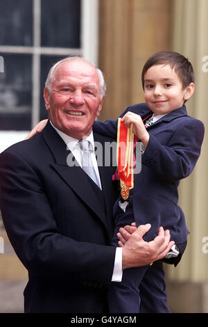 L'ancien champion britannique de boxe poids lourd Sir Henry Cooper avec son petit-fils Henry James, âgé de cinq ans, après avoir reçu un chevalier lors d'une cérémonie d'investiture au Palais de Buckingham. Banque D'Images