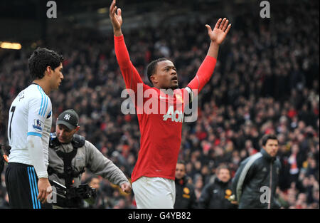 Patrice Evra, de Manchester United, célèbre la victoire alors que Luis Suarez, de Liverpool, part à l'occasion du match de la Barclays Premier League à Old Trafford, Manchester. Banque D'Images