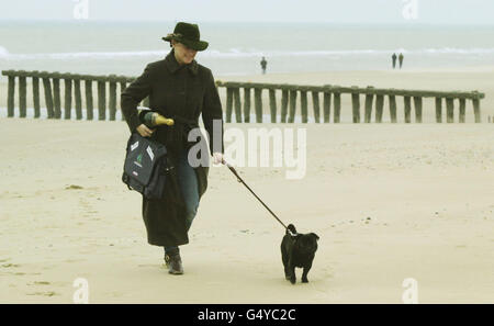 Frodo Baggins le pug marche sur la plage de Calais avec son propriétaire Helen de Borchgrave. Ce chien de cinq ans naviguera jusqu'à Douvres, le premier animal à arriver en Grande-Bretagne dans le cadre du nouveau système de passeport pour animaux de compagnie, à la suite de l'adoption de la loi de quarantaine vieille de plusieurs siècles. * les chiens et les chats de 21 pays européens seront maintenant admis en Grande-Bretagne à condition qu'ils aient un passeport valide, une puce d'identité implantée et la preuve d'une vaccination contre la rage. Banque D'Images