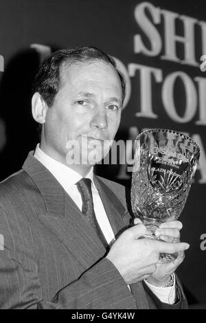 Ron Dennis, le patron de l'équipe de Formule 1 de McLaren, reçoit le prix Shell World Formula One Driver Champion au nom de son pilote Alain Prost aux Shell Motor Sport Awards à Londres Banque D'Images