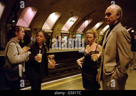 Deux adolescentes marchent devant les cire de la chanteuse Kylie Minogue et de l'acteur Sean Connery de Madame Tussaud, sur la plate-forme de la station de métro Baker Street à Londres. Banque D'Images