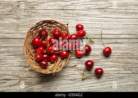 Panier de cerises fraîches sur la table en bois. Banque D'Images