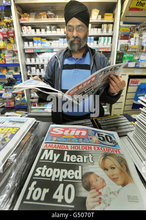 M. Tajinder Sagoo étudie le nouveau Sun dans son magasin de nouvelles Woodford du sud, le jour de la première édition du titre. Banque D'Images