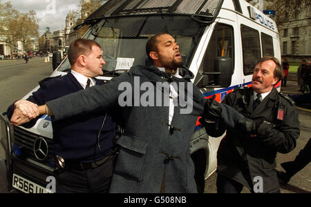 Un manifestant de Whitehall est bridé par la police lors des manifestations contre le génocide en Tchétchénie, à l'arrivée du président russe Vladimir Poutine à Downing Street, Londres, pour rencontrer le Premier ministre Tony Blair lors de sa première visite à l'étranger depuis son arrivée au pouvoir. * ...et prendre le thé avec la reine Elizabeth II à Windsor. Banque D'Images