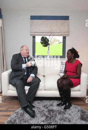 Eric Pickles, Secrétaire des communautés, Il a une tasse de thé avec Sarah Okungu, une résidente locale, au développement de Meadowland de London Thames Gateway Development Corporation (LTGDC) à Barking Riverside, dans l'est de Londres, au cours de sa visite et visite du site et de l'observation d'un salon récemment ouvert lié au développement des 300 maisons Être construit dans le cadre de la première phase du projet Barking Riverside. Banque D'Images