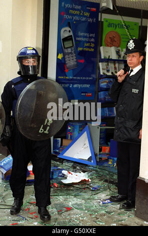 Des policiers anti-émeutes et des officiers se tiennent à l'extérieur de l'entrepôt de Carphone dans le centre de Strand, à Londres.Des milliers de manifestants anticapitalistes se sont rassemblés pour le dernier jour d'une manifestation de quatre jours sur le capitalisme mondial, des violences ont éclaté alors que la police s'est affrontée avec des manifestants. Banque D'Images