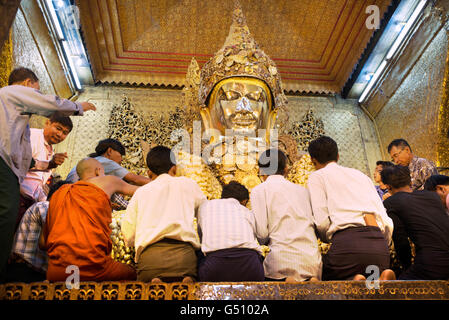 Les croyants en face de l'immense Bouddha d'or de la Pagode Mahamuni, Mandalay, Myanmar Banque D'Images