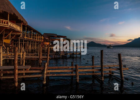 Le soleil se couche sur le Lago de Atitlan au Guatemala, et les touristes et les habitants de recueillir par les quais à Panajachel comme dernier bateaux viennent Banque D'Images