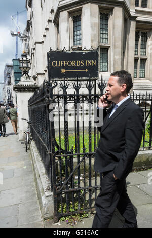 Un homme adapté debout à côté de la signalisation Clifford's Inn, Chancery Lane, Londres, Royaume-Uni Banque D'Images