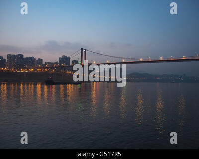 La Chine, Chongqing, croisière sur le Yangtze River, ville illuminée et pont sur la rivière Yangtze à Zhongxian Banque D'Images