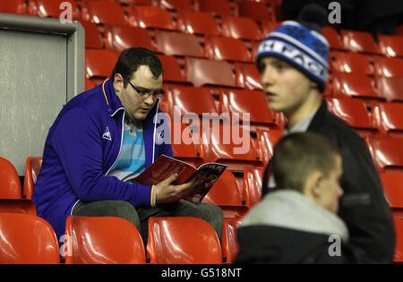 Football - Barclays Premier League - Liverpool / Everton - Anfield.Un fan d'Everton lit le programme d'allumette dans les stands Banque D'Images