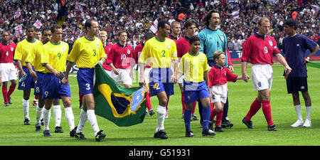 Les deux équipes sont dirigées sur le terrain par leurs capitaines, le Cafu brésilien (n° 2) et l'Alan Shearer d'Angleterre (n° 9) avant leur match international amical au Wembley Stadium, Londres.* Score final: Angleterre 1 Brésil 1. Banque D'Images