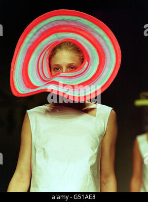 Un mannequin portant une tenue et un chapeau coloré d'un designer diplômé du London College of Fashion marche le podium, lors du défilé de mode des diplômés du Planet 2000 à Londres. Banque D'Images