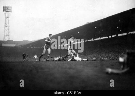 Bill Foulkes, Manchester United en arrière (à gauche de l'image), et Eddie Colman, la moitié droite de Manchester United, viennent à l'aide de leur moitié centrale John 'Jackie' Blanchflower qui a roulé sur le sol avec un vrai joueur de Madrid (chemise blanche) pendant la demi-finale de la coupe d'Europe, Deuxième match de jambe. Le résultat a été un tirage de 2-2 donnant au Real Madrid un total gagnant de 5-3 Banque D'Images