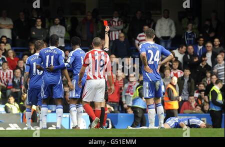 Ricardo Fuller de la ville de Stoke (caché) est envoyé par l'arbitre André Marriner pour un timbre sur Branislav Ivanovic de Chelsea (au sol) Banque D'Images