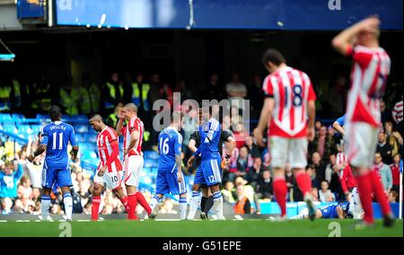 Ricardo Fuller, de la ville de Stoke (10), sort du terrain abattu après avoir été envoyé par l'arbitre André Marriner pour un timbre sur Branislav Ivanovic, de Chelsea (sur le sol) Banque D'Images