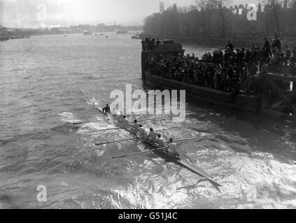 L'équipage d'Oxford passe sous Hammersmith Bridge, en eau brute.La course nautique universitaire de 1912 est unique dans l'histoire de la course comme étant la seule occasion où les deux équipages ont coulé. Banque D'Images