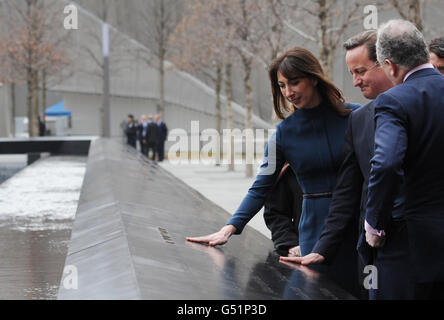 Le Premier ministre David Cameron (au centre partiellement obscurci) et sa femme Samantha (à gauche) touchent un mémorial à 9/11 victimes où la citoyenne britannique Katherine Wolf se souvient, sur le site Ground Zero, à New York. Banque D'Images