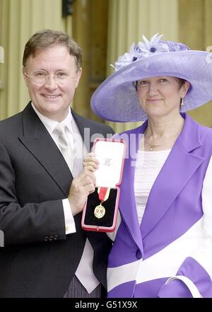 Sir Michael Lyons avec sa femme Jane après avoir reçu une chevalier de la reine Elizabeth II lors d'une cérémonie d'investiture qui s'est tenue au palais de Buckingham. 15/03/04: Sir Michael Lyons, directeur de l'Institut d'études sur les gouvernements locaux de l'Université de Birmingham, qui annonce des propositions plus tard, pour un changement énorme d'emplois dans la fonction publique loin de Londres et du Sud-est. Le déménagement de 20,000 des 240,000 emplois du service hors de Whitehall coûtera des centaines de millions, mais on s'attend à ce que les économies soient de 2 milliards d'ici 15 ans et Sir Michael a déclaré que le nombre d'emplois transférés vers le Banque D'Images