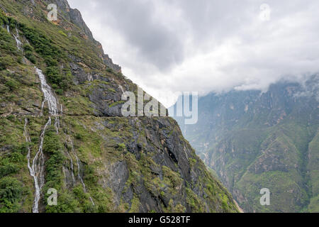 La Chine, le Yunnan Diqing Sheng, Zangzuzizhizhou, randonnée pédestre (2 journée) à la Gorge du tigre bondissant de la rivière Yangtze, falaises abruptes sous couverture de nuage blanc Banque D'Images