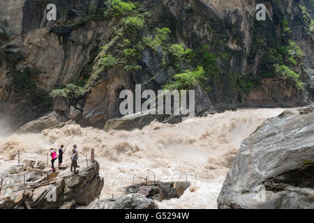 La Chine, le Yunnan Diqing Sheng, Zangzuzizhizhou, randonnée pédestre (2 journée) à la Gorge du tigre bondissant de la rivière Yangtze, les touristes sur un rocher dans la rivière Banque D'Images