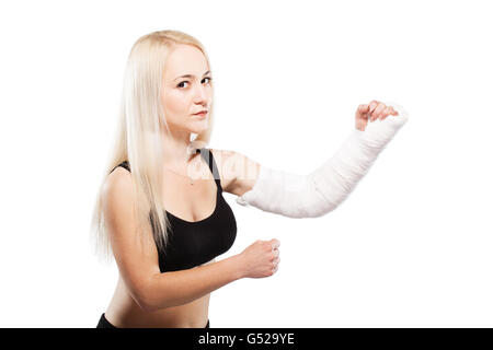 Fille blonde de remise en forme avec un bras cassé dans le plâtre, pose de boxe Banque D'Images