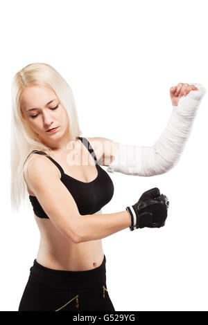 Fille blonde de remise en forme avec un bras cassé dans le plâtre, pose de boxe Banque D'Images