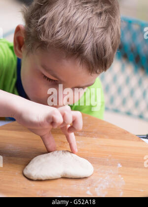 L'Afrique du Sud, Johannesburg, Gauteng, petit garçon avec le pétrissage de la pâte, pizza doughcreation Banque D'Images