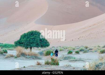 La Namibie, Sossusvlei, Hardap, mère avec fils lors d'une randonnée dans le désert, au lever du soleil Banque D'Images