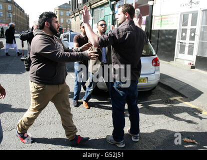 Le protestataire Thomas Johnson (à droite), est confronté par les partisans de George Galloway après qu'il a lancé des œufs sur le député de Bradford, avant une visite en bus à ciel ouvert après sa victoire lors des dernières nuits de l'élection partielle de Bradford West. Banque D'Images