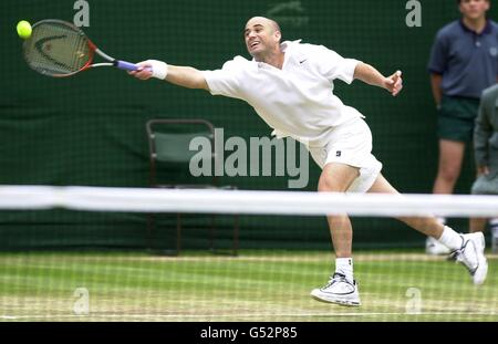 PAS D'UTILISATION COMMERCIALE : l'américain Andre Agassi atteint le ballon lors du match de demi-finale contre l'australien Pat Roaprès à Wimbledon 2000. Banque D'Images