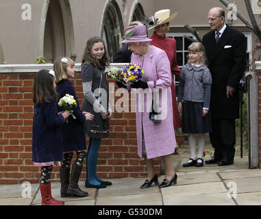 La reine Elizabeth II reçoit des fleurs lorsqu'elle quitte la chapelle Saint-Georges du château de Windsor après avoir assisté au service des Mattins de Pâques avec le duc d'Édimbourg (à droite), la comtesse de Wessex (à gauche) et Lady Louise Windsor. Banque D'Images