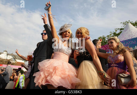 Les Racegoers profitent du soleil en début de soirée pendant la deuxième journée de la réunion nationale de John Smith de 2012 à l'hippodrome d'Aintree, à Liverpool. Banque D'Images