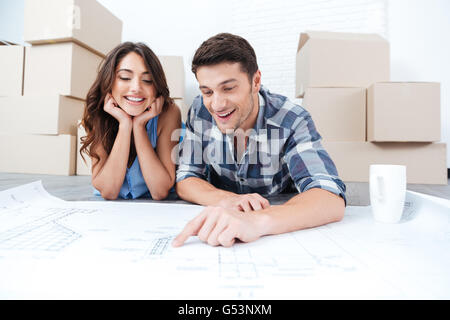 Happy couple looking at blueprints à nouvelle maison Accueil Banque D'Images