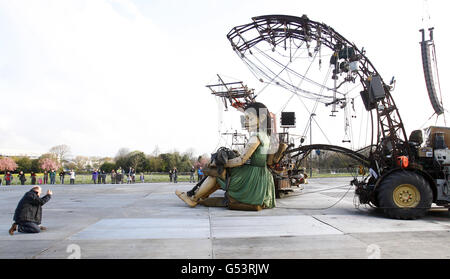 Un membre du public prend une photo du géant de la petite fille, une marionnette géante créée par des experts Royal de Luxe (RDL) dans le cadre de Sea Odyssey, une histoire d'amour basée autour du naufrage du Titanic, dans le parc Stanley de Liverpool. Banque D'Images