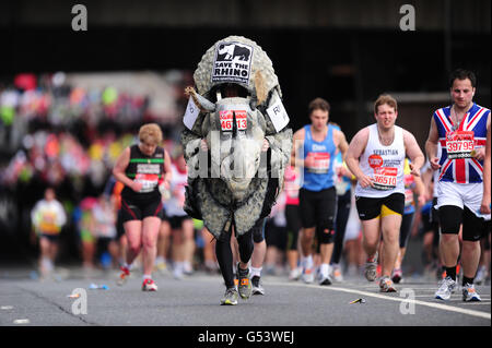 Un concurrent s'habille comme un Rhino lors du 32e marathon de Virgin London à Londres. Banque D'Images