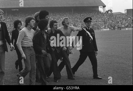 HOOLIGANISME FOOTBALL 1978 : un défenseur de Milwall (3e r), avec le sang versé d'une blessure oculaire, est conduit pour traitement par un compagnon de la Den, New Cross, Londres, après la violence du football.La police et les supporters de Millwall ont mené une bataille de course pendant le 6e match de la coupe Millwall v Ipswich Town FA. Banque D'Images