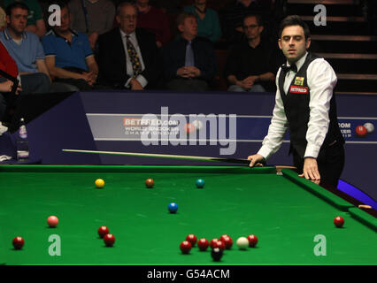 Le Ronnie O'Sullivan, en Angleterre, regarde le signal à côté d'un rouge lors d'un snooker lors de son match avec le Neil Robertson en Australie lors des championnats du monde de snooker Betfred.com au Crucible Theatre, Sheffield. Banque D'Images