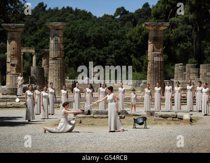 La flamme olympique est éclairée par une actrice habillée comme la haute prêtresse, utilisant un miroir parabolique pour refléter les rayons du soleil, lors d'une répétition pour la cérémonie de demain, Ce qui indique au monde que le compte à rebours des Jeux de Londres 2012 a commencé, au Temple de Hera à Olympia, en Grèce, où les Jeux Olympiques anciens ont eu lieu. Banque D'Images