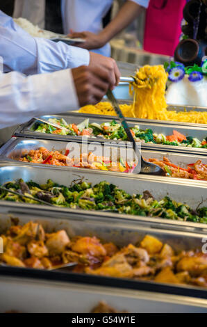 Les gens à s'aider eux-mêmes à l'alimentation à un buffet self-service lors d'une fête. Banque D'Images