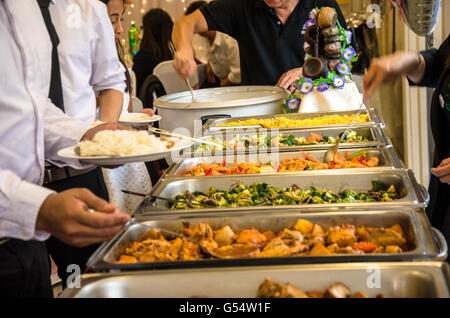 Les gens à s'aider eux-mêmes à l'alimentation à un buffet self-service lors d'une fête. Banque D'Images