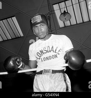 Les grands poings du boxeur américain Muhammad Ali (anciennement Cassius Clay) sont prêts à faire la bataille. Ici, il est vu dans l'attitude de parcimonie pour son championnat du monde de poids lourd de combat contre la Grande-Bretagne Henry Cooper au stade Highbury, Londres. Banque D'Images