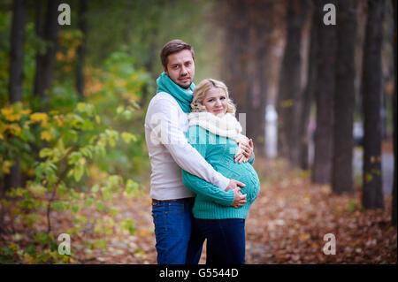 Mari et femme enceinte sont à pied dans le parc en automne Banque D'Images