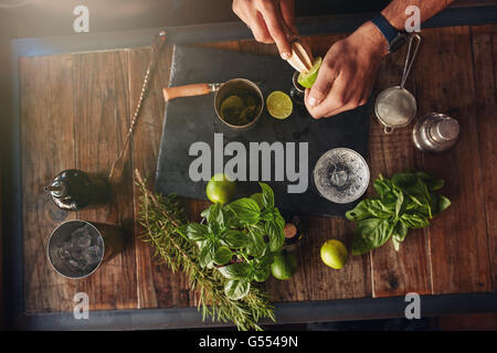 Le jus de citron avec les mains du barman d'un alésoir. L'expérience de barman créant de nouvelles idées de cocktails. Accessoires Cocktail wit Banque D'Images